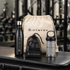 The Workout Ready Kit by GiftNYou with black water bottle, black skipping rope with mesh storage pouch, grey towel in a clear carry container in a fitness setting
