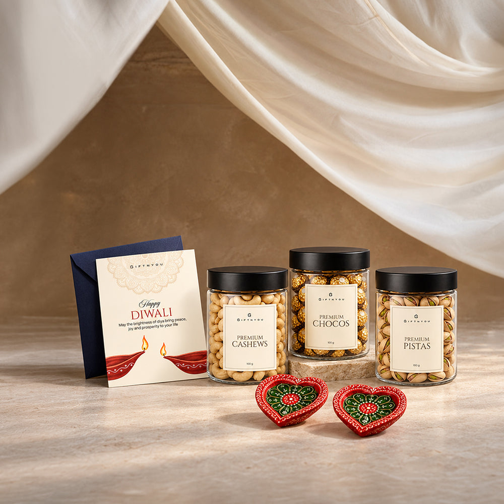 Cashew, pistachio and chocolate jars with two decorative diyas and a Diwali greeting card